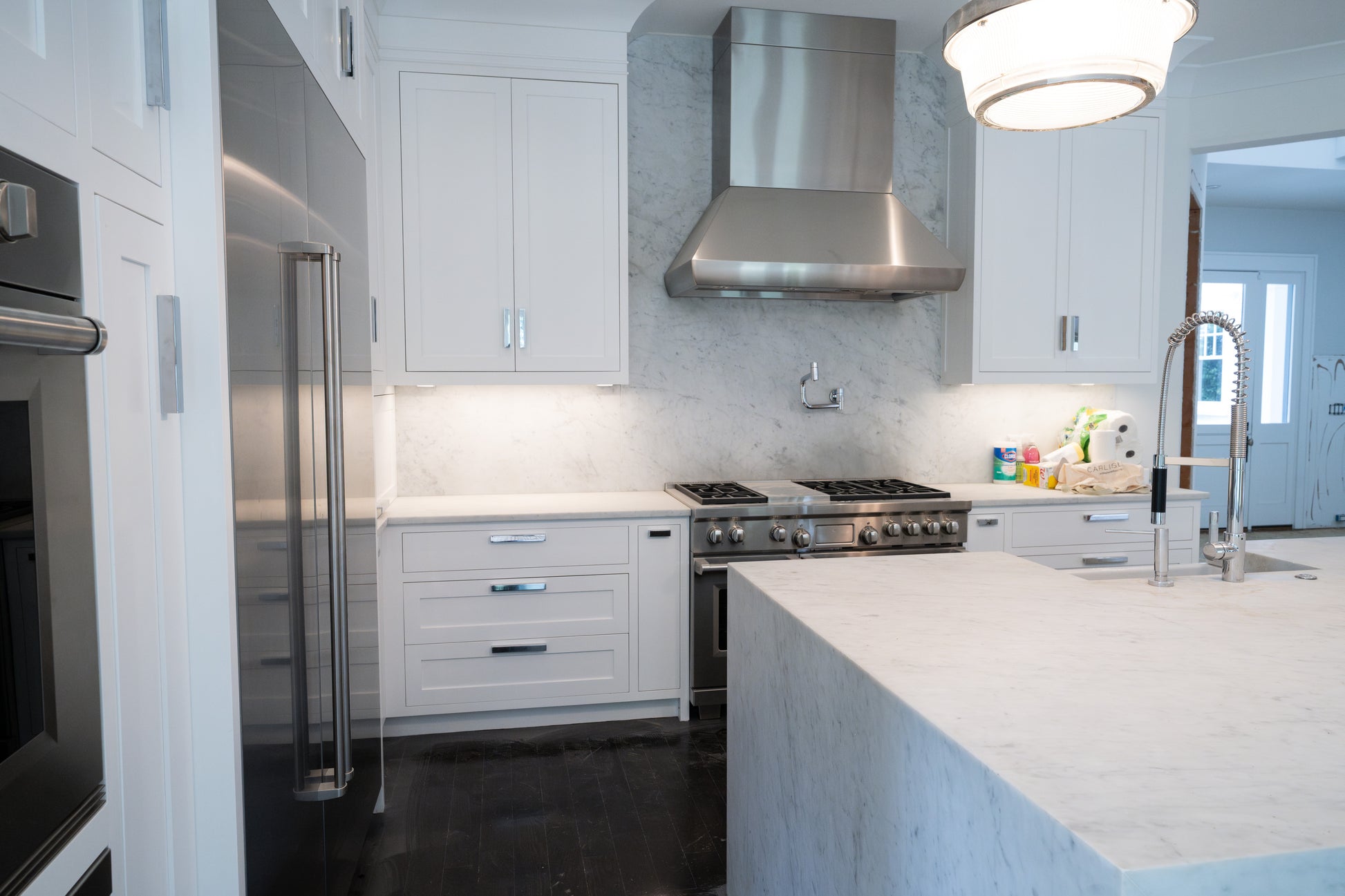 Spacious social kitchen island in transitional white with white quartz countertops and undermount sink