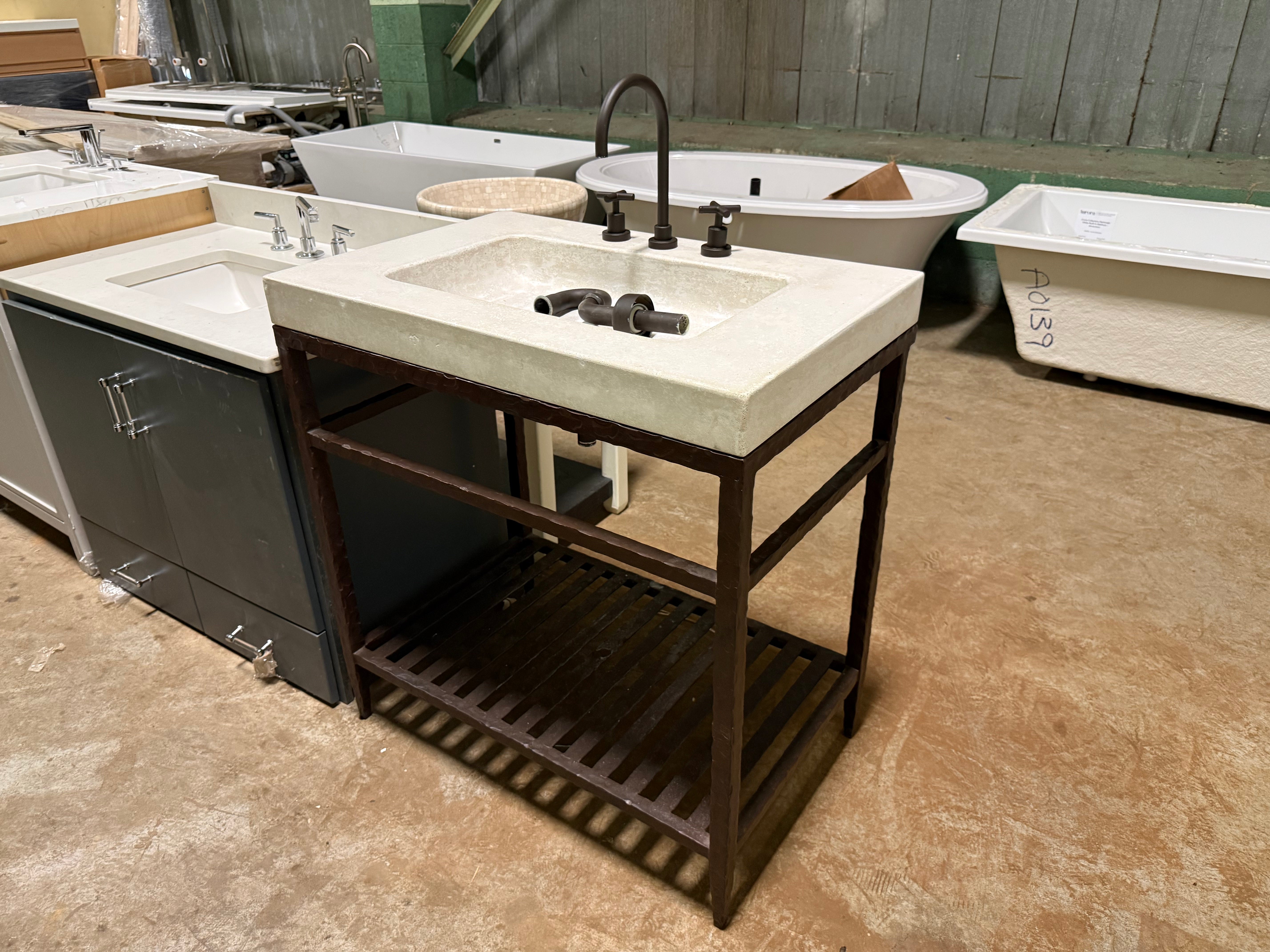 Close up view of the integrated sink top and matching black mono faucet on the custom industrial 34 inch vanity