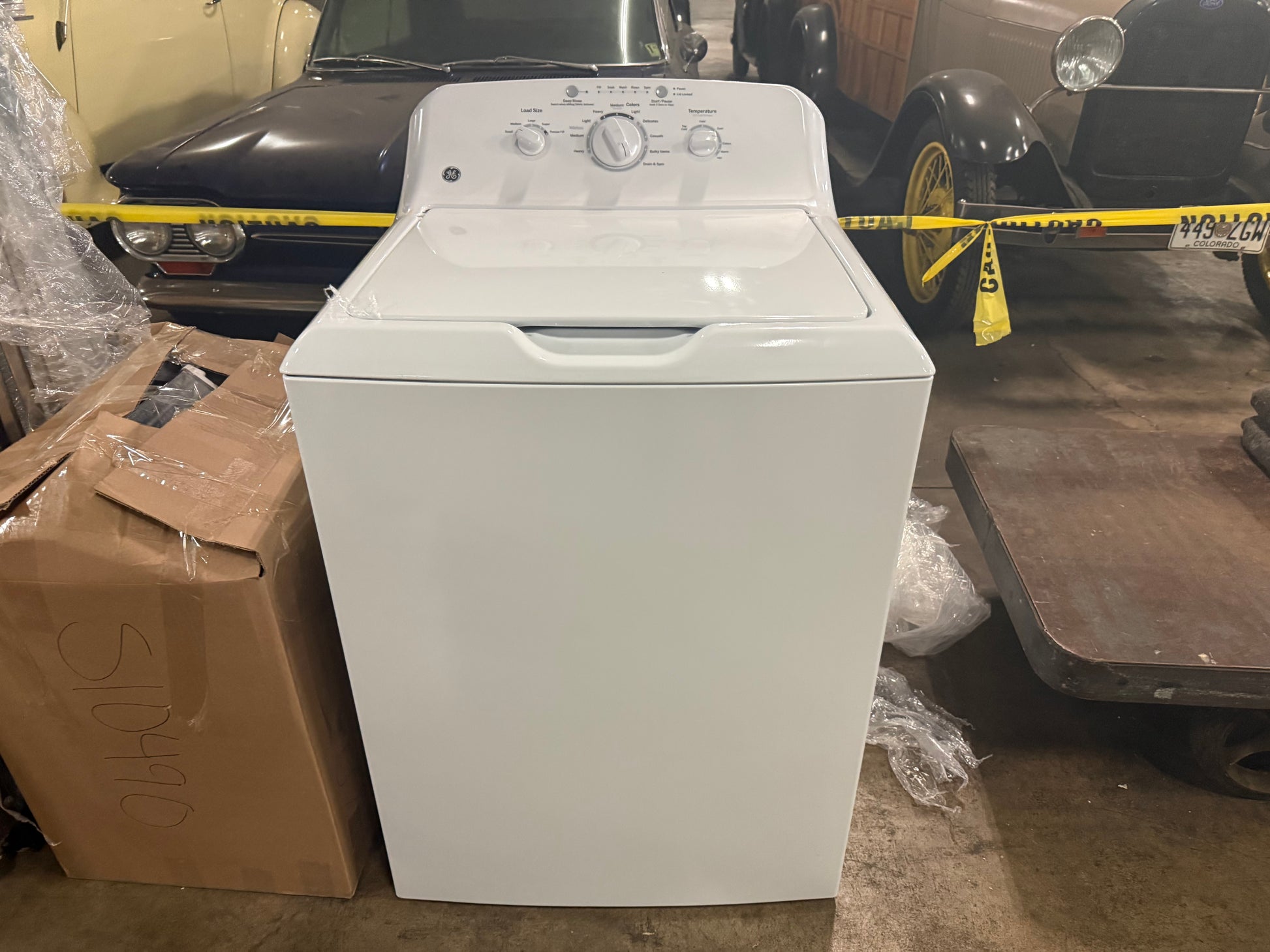 Interior view of the open top lid showing the stainless steel basket and the heavy duty dual action agitator inside the GE washing machine