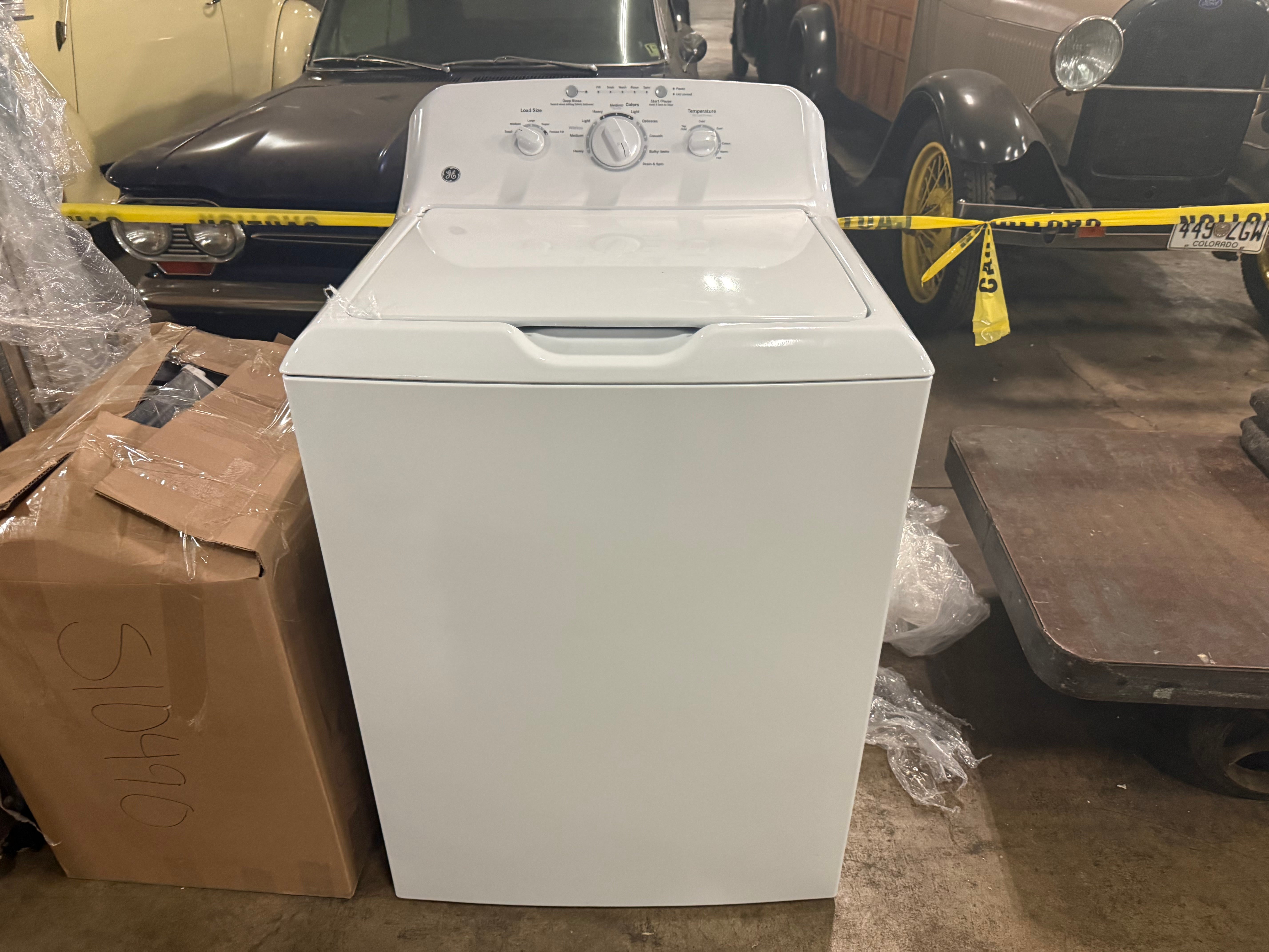 Interior view of the open top lid showing the stainless steel basket and the heavy duty dual action agitator inside the GE washing machine