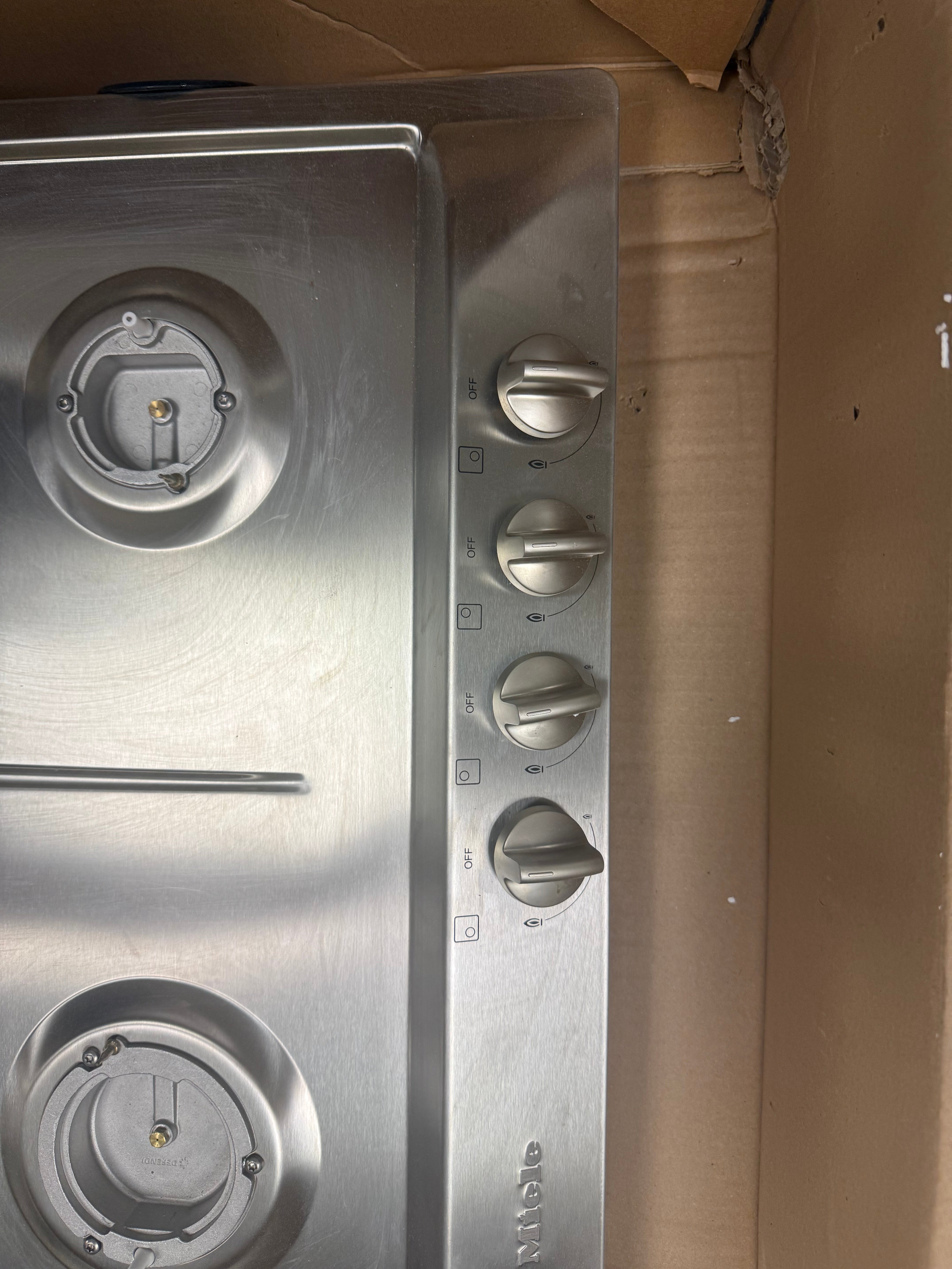 Close up of front control knobs and sealed gas burners on the Miele KM360LP cooktop