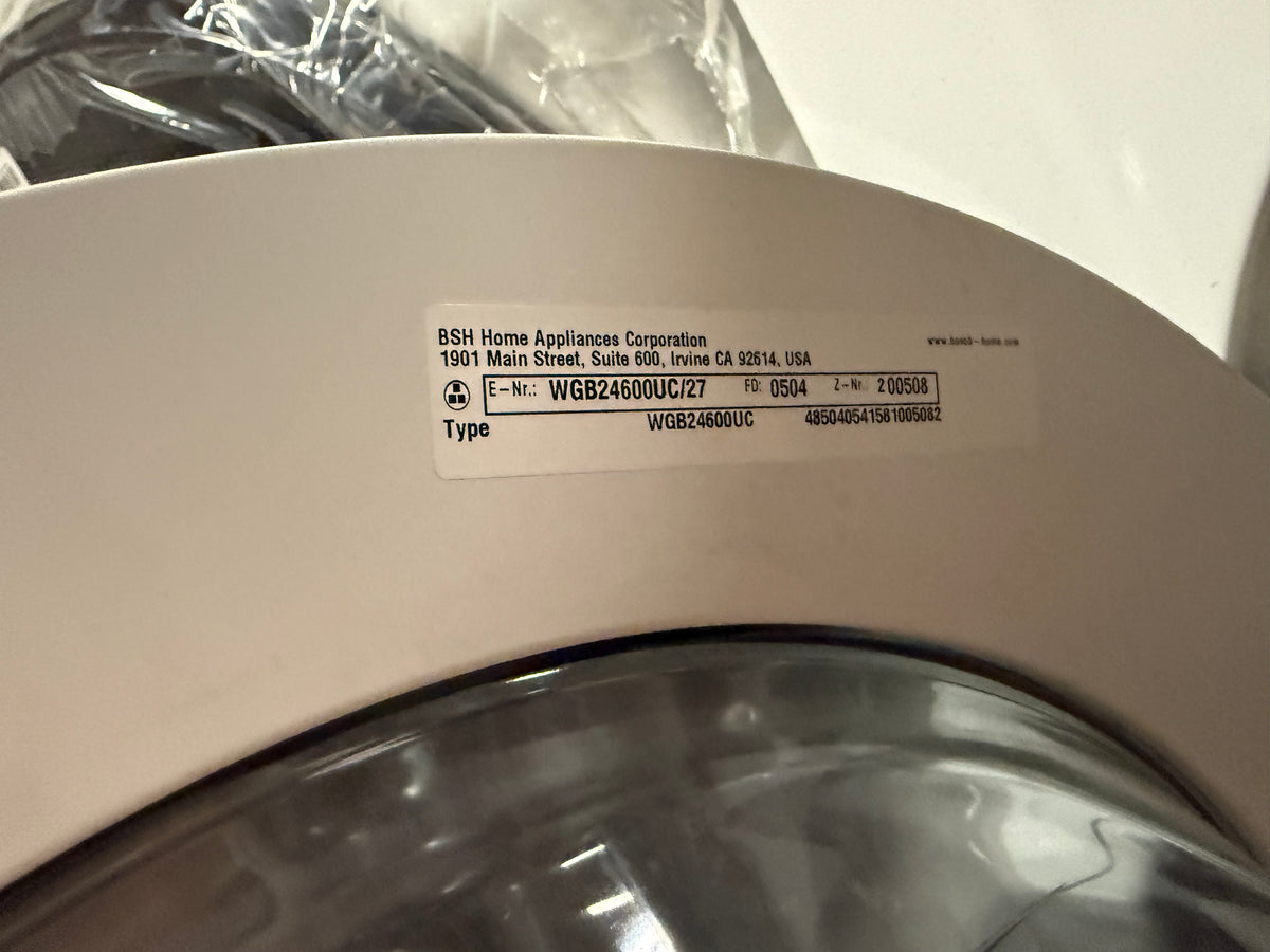 Close-up of a white appliance door with a printed BSH Home Appliances Corporation label and a clear circular window below it.