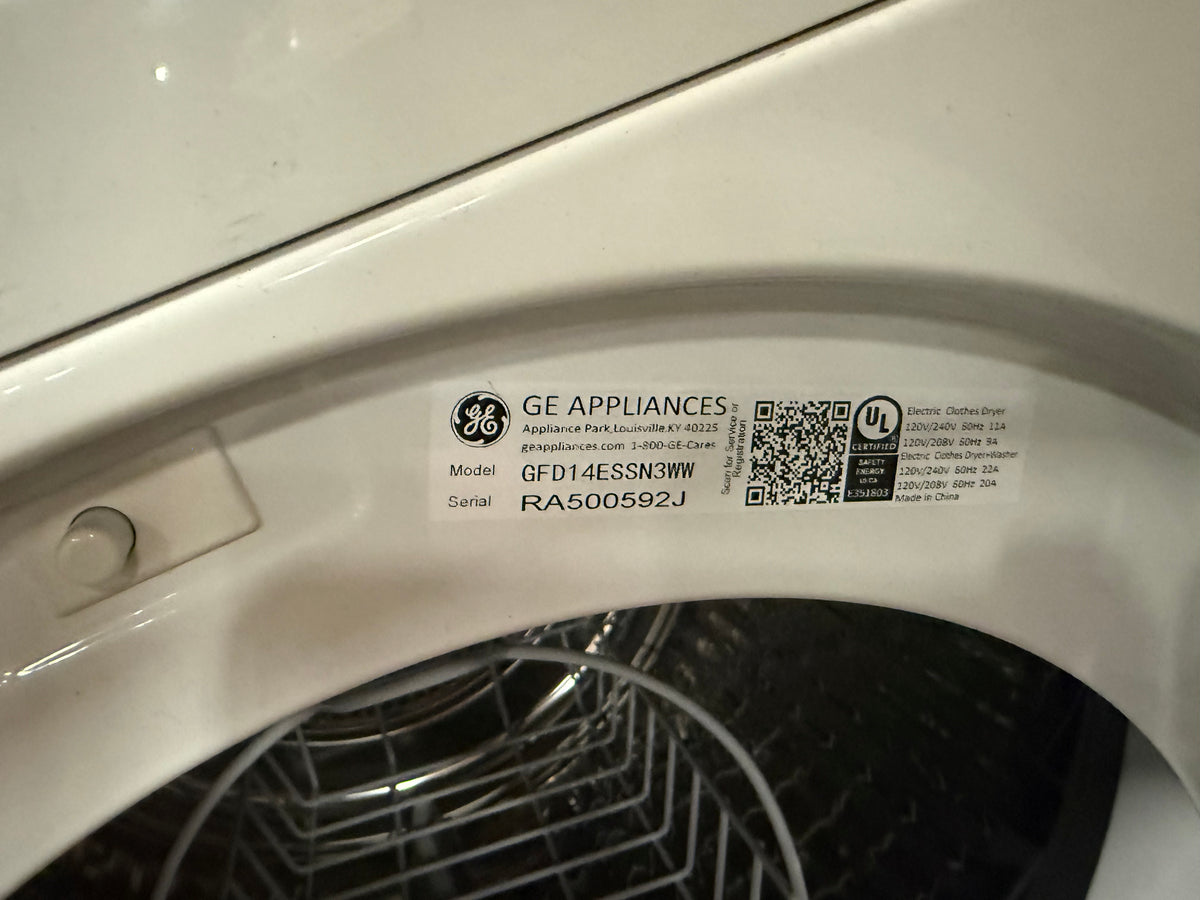 A close-up of a GE Appliances appliance label sticker on the white inner door of a washing machine, showing the model GFD14ESSN3W and serial RA500592J.
