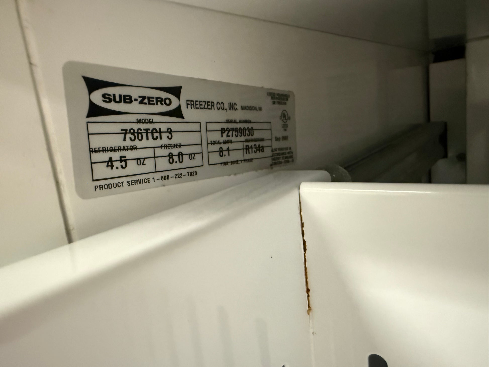 A close-up of a Sub-Zero freezer product label on a white appliance interior, showing the model 736TCI 3 and manufacturer information.