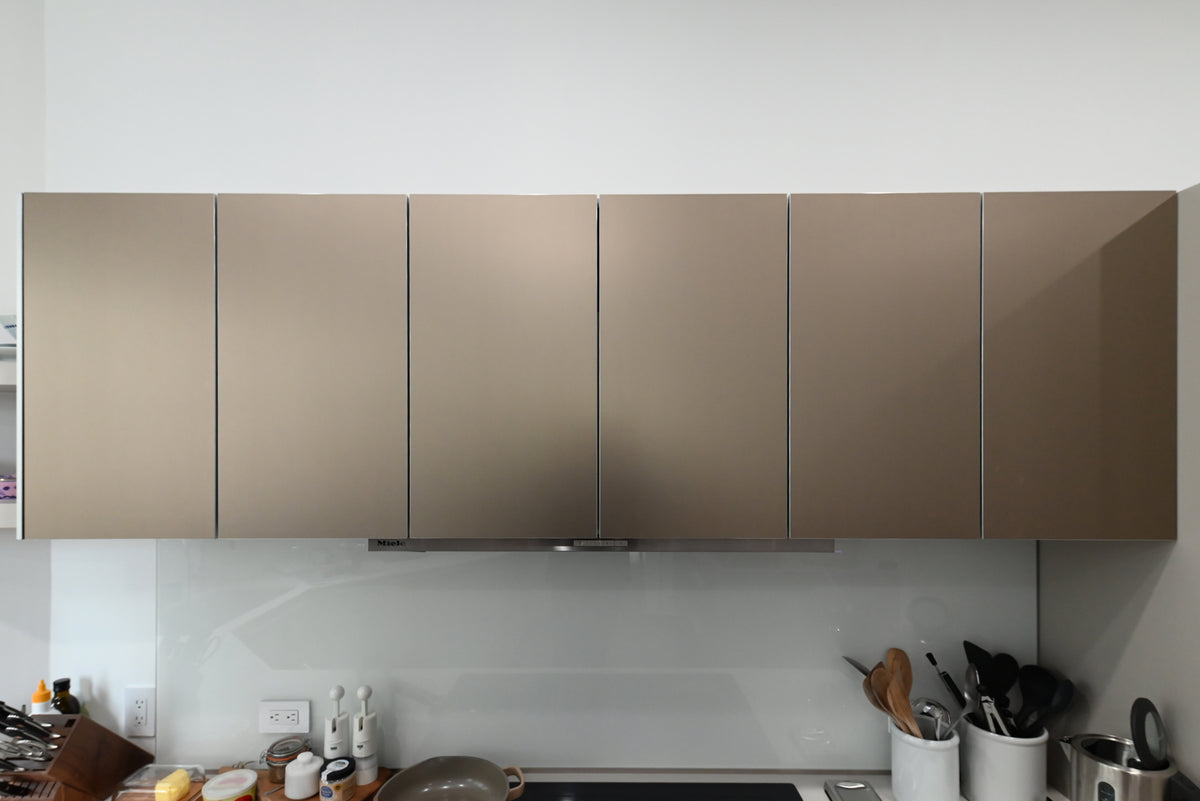 Bulthaup Modern Metallic Bronze Upper Cabinets with Glass Backsplash and Miele Hood Insert