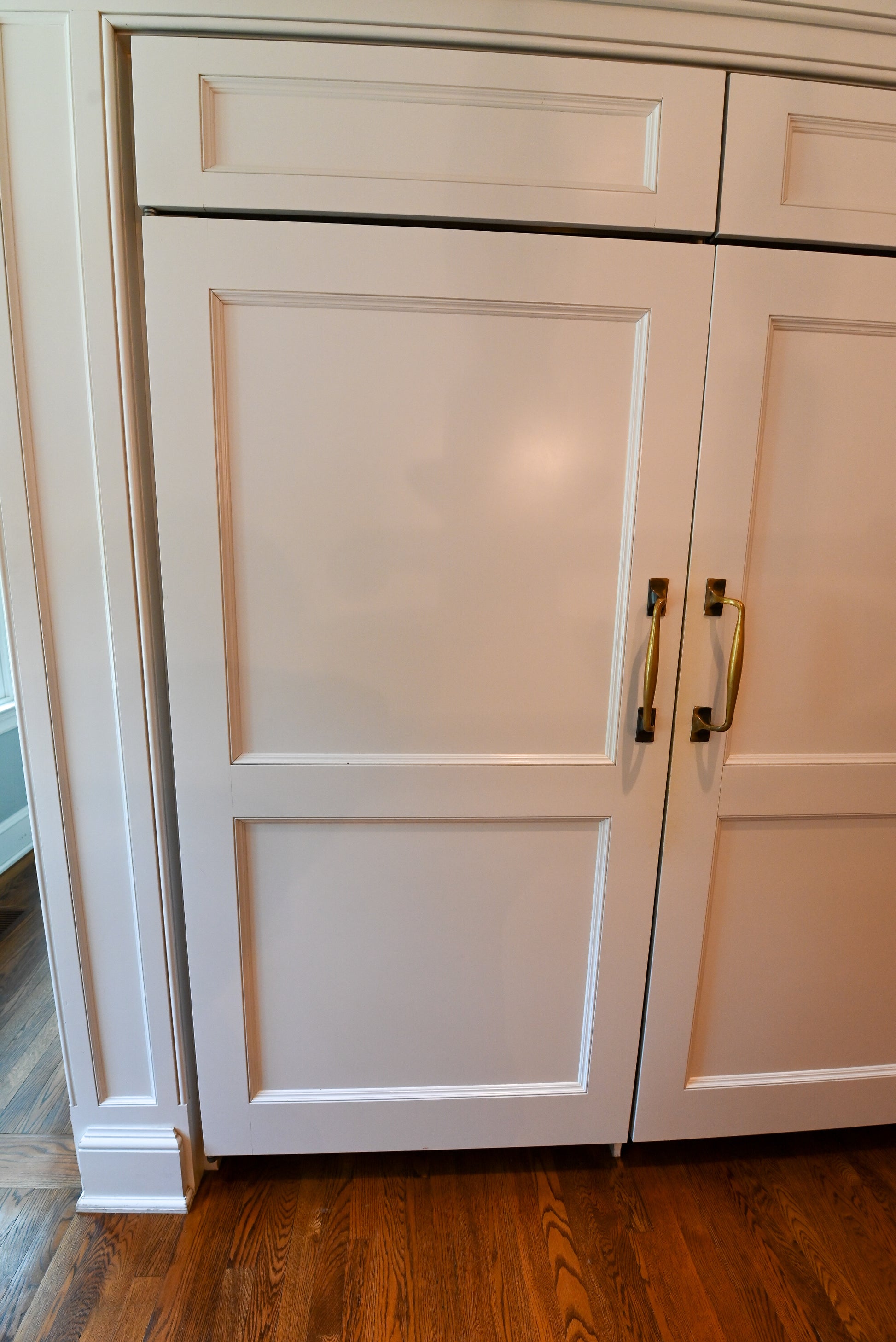 Close up view of the 48 inch Wolf professional dual fuel range installed with white shaker cabinets and stone countertops