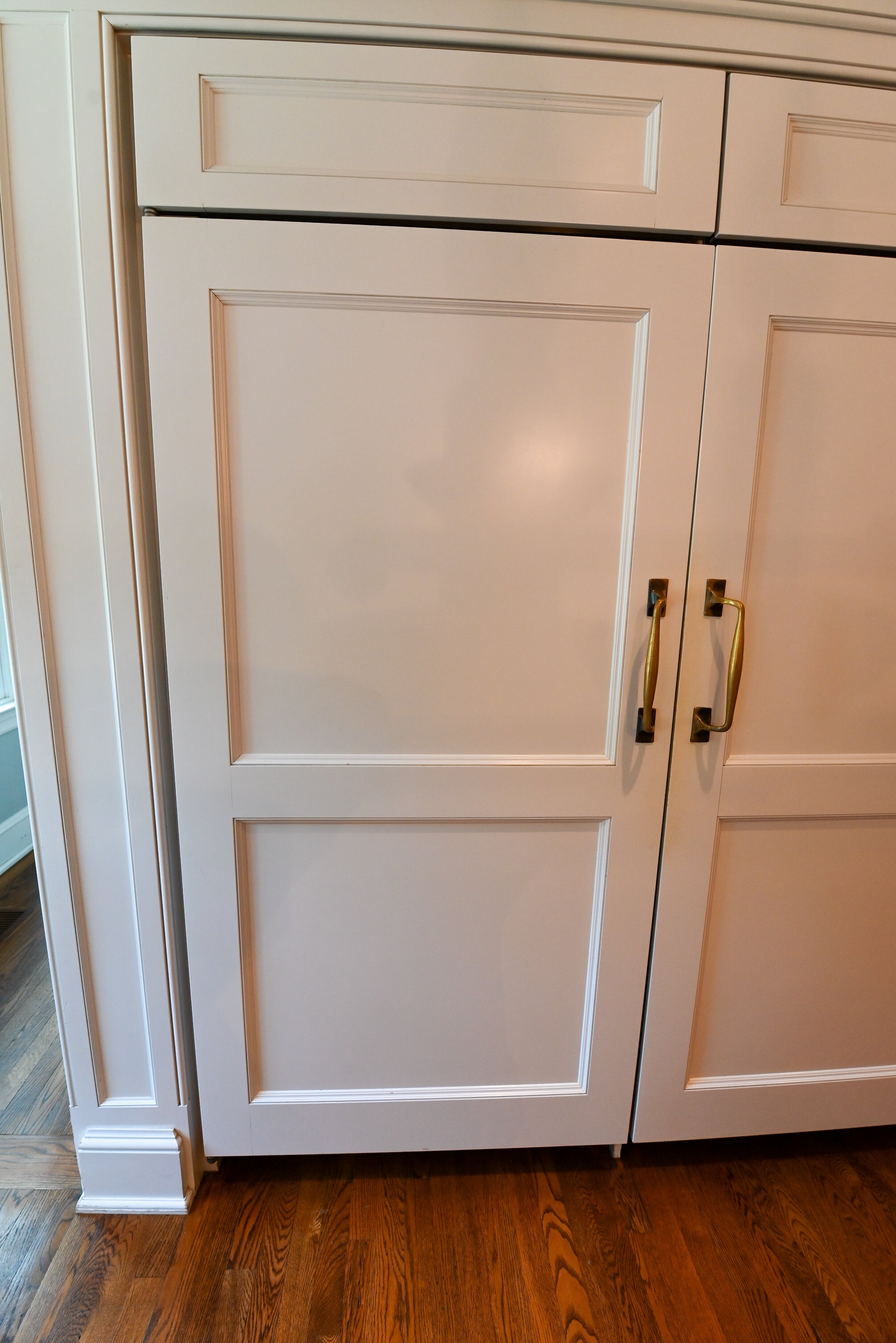 Close up view of the 48 inch Wolf professional dual fuel range installed with white shaker cabinets and stone countertops