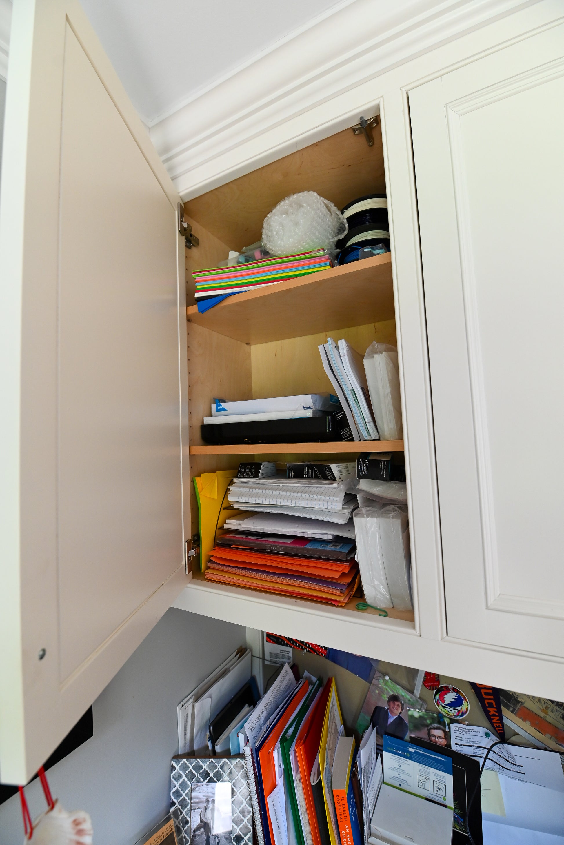 Close up view of the solid wood desktop surface and soft close shaker drawer pulls on the transitional white built in desk