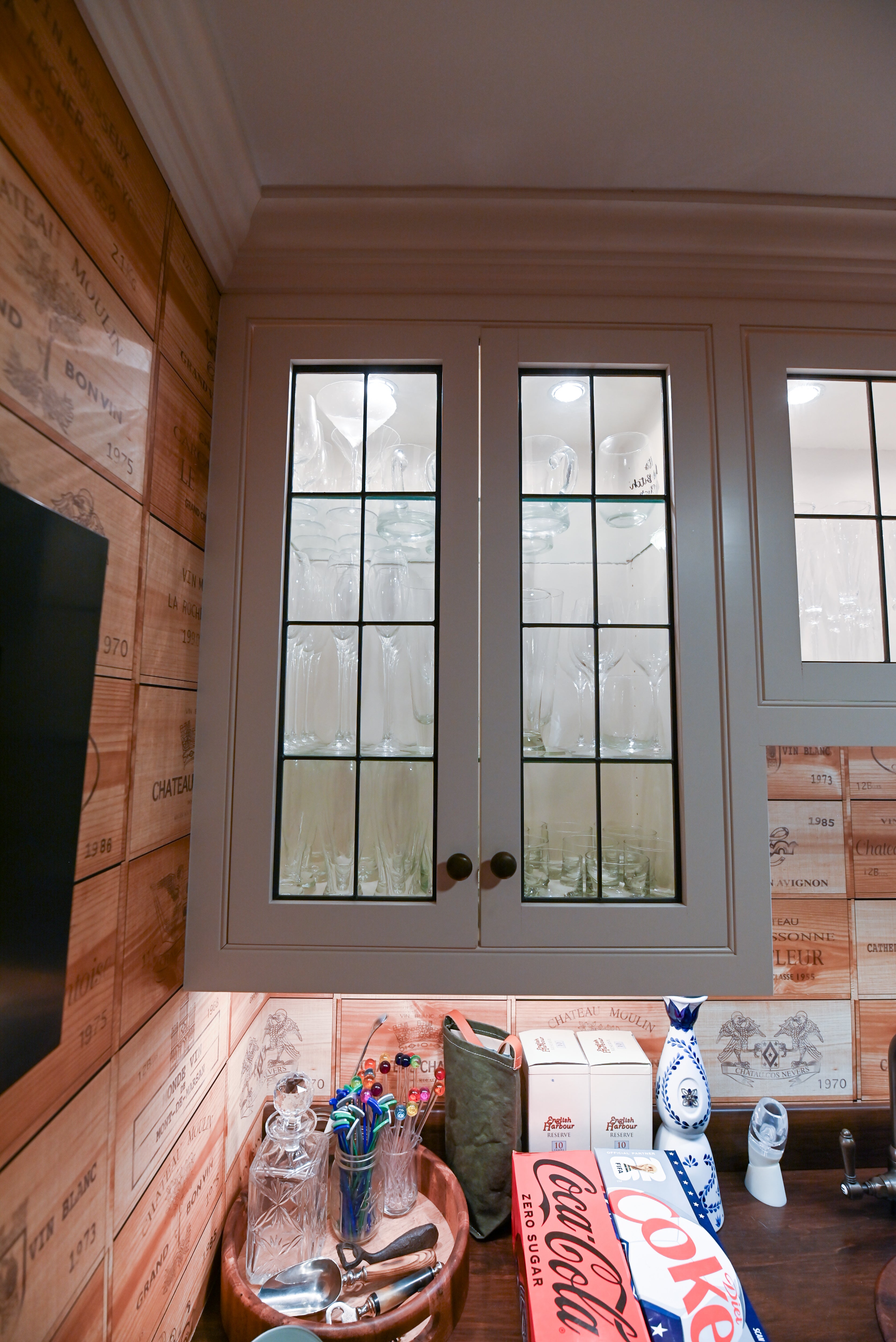 The Montclair transitional white wet bar package featuring custom shaker cabinetry glass upper display and Sub Zero refrigeration