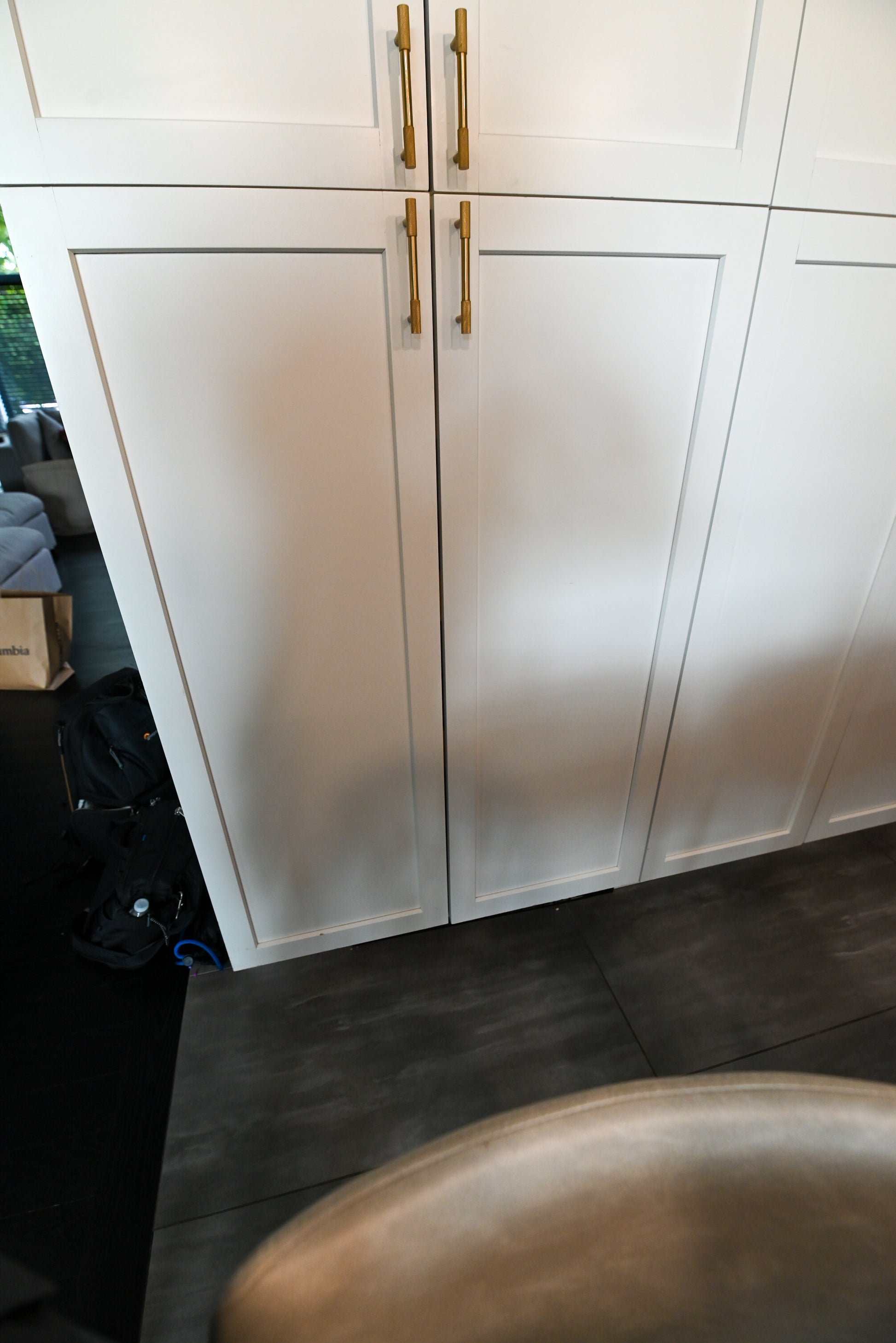 The Lexington transitional kitchen display set featuring white shaker perimeter cabinetry, black center island, and integrated appliances