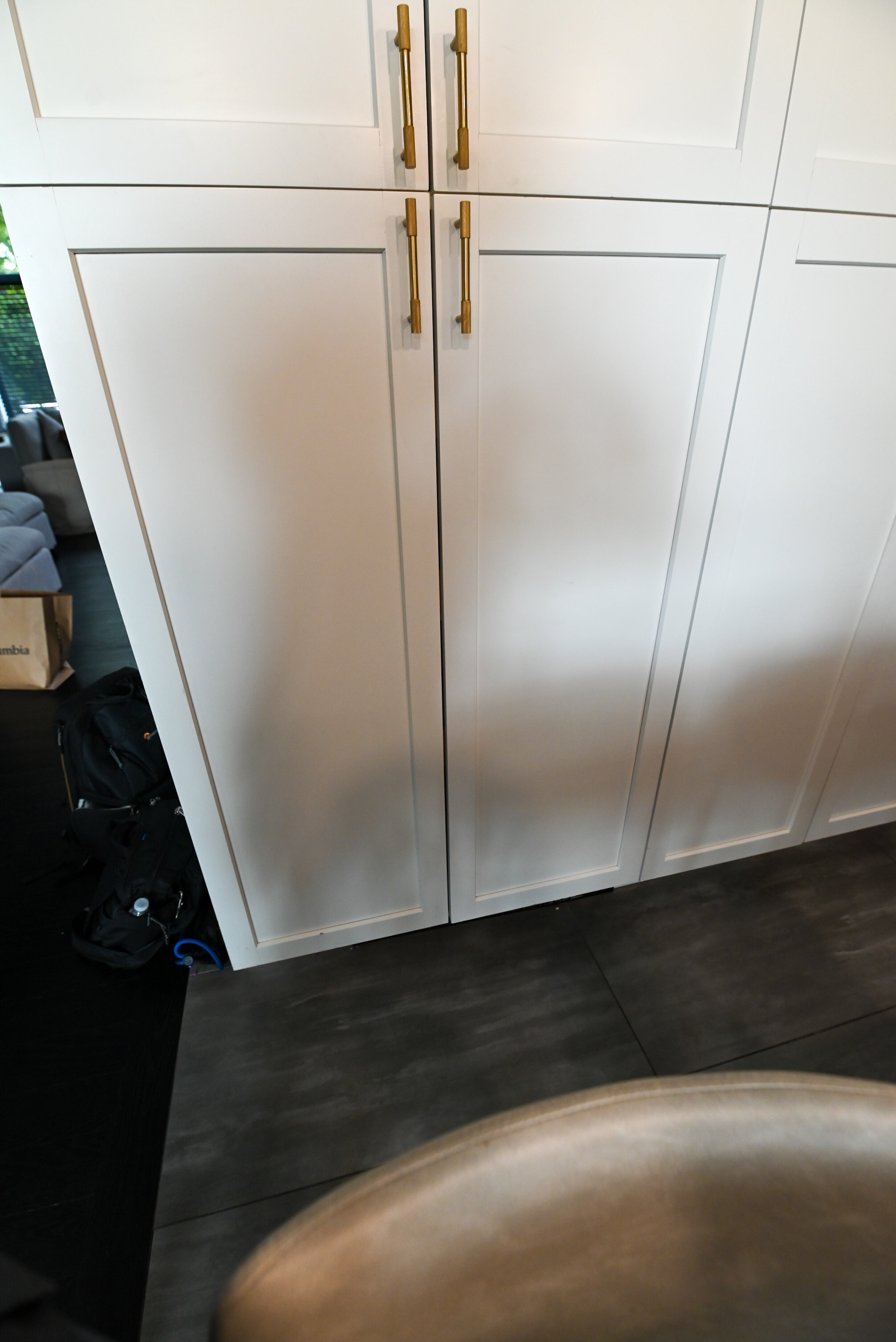 The Lexington transitional kitchen display set featuring white shaker perimeter cabinetry, black center island, and integrated appliances