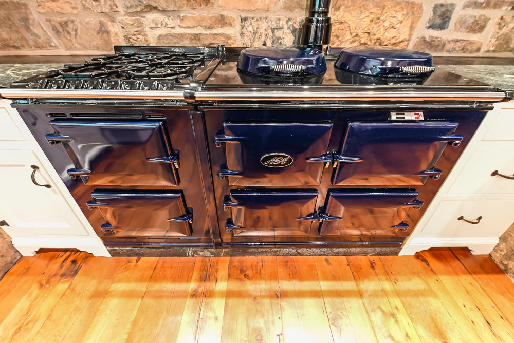 Rustic Traditional White & Navy Kitchen with Black AGA Range, Wood Top Island & Soapstone Countertops