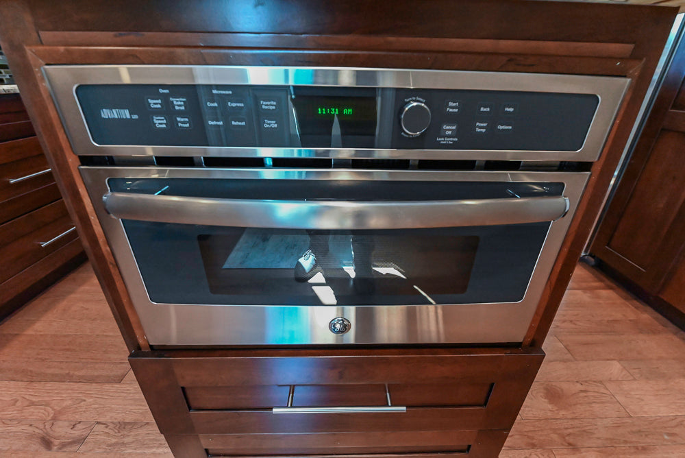 Kraftmaid Transitional Dark Wooden Kitchen with Marble Countertops and GE Monogram Appliances