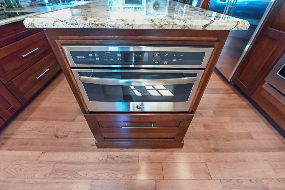 Kraftmaid Transitional Dark Wooden Kitchen with Marble Countertops and GE Monogram Appliances
