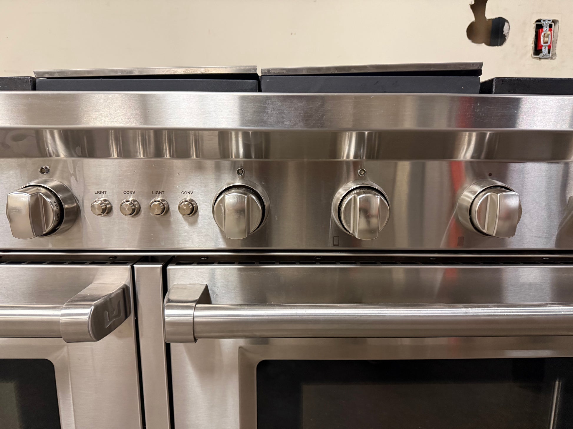 Macro shot of the stainless steel bezels and the tactile texture of the burner control dials.