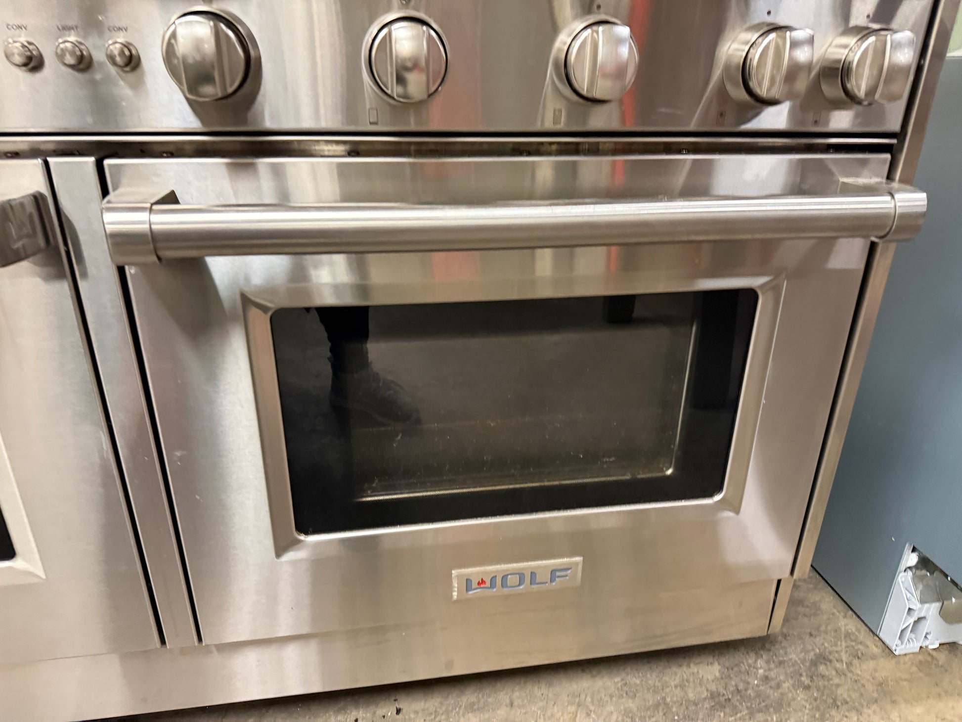 Stainless steel oven with visible brand logo on a gray background