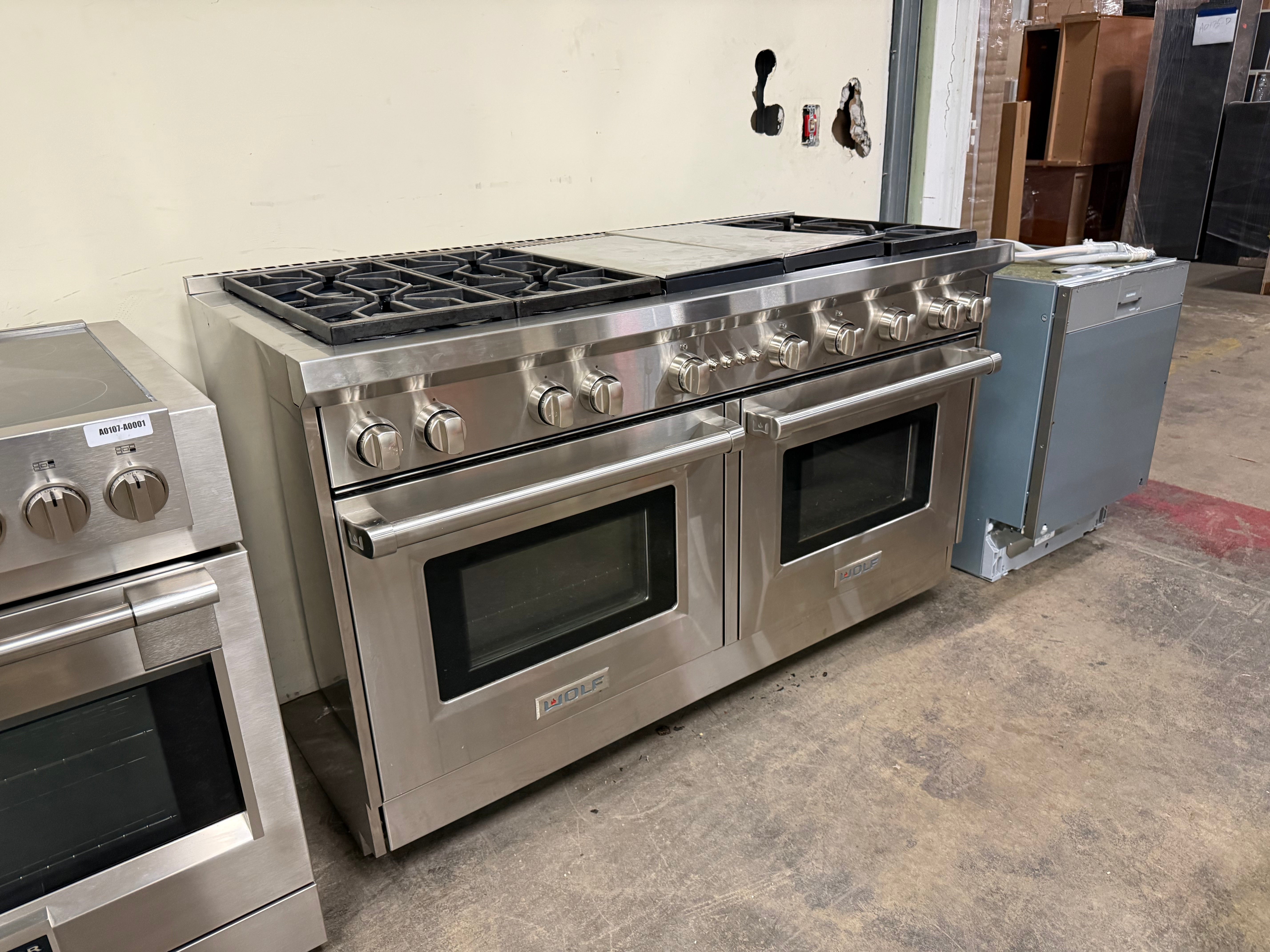 Frontal view of the Wolf GR606CG showing the symmetrical layout of the cooktop and large stainless steel oven doors.