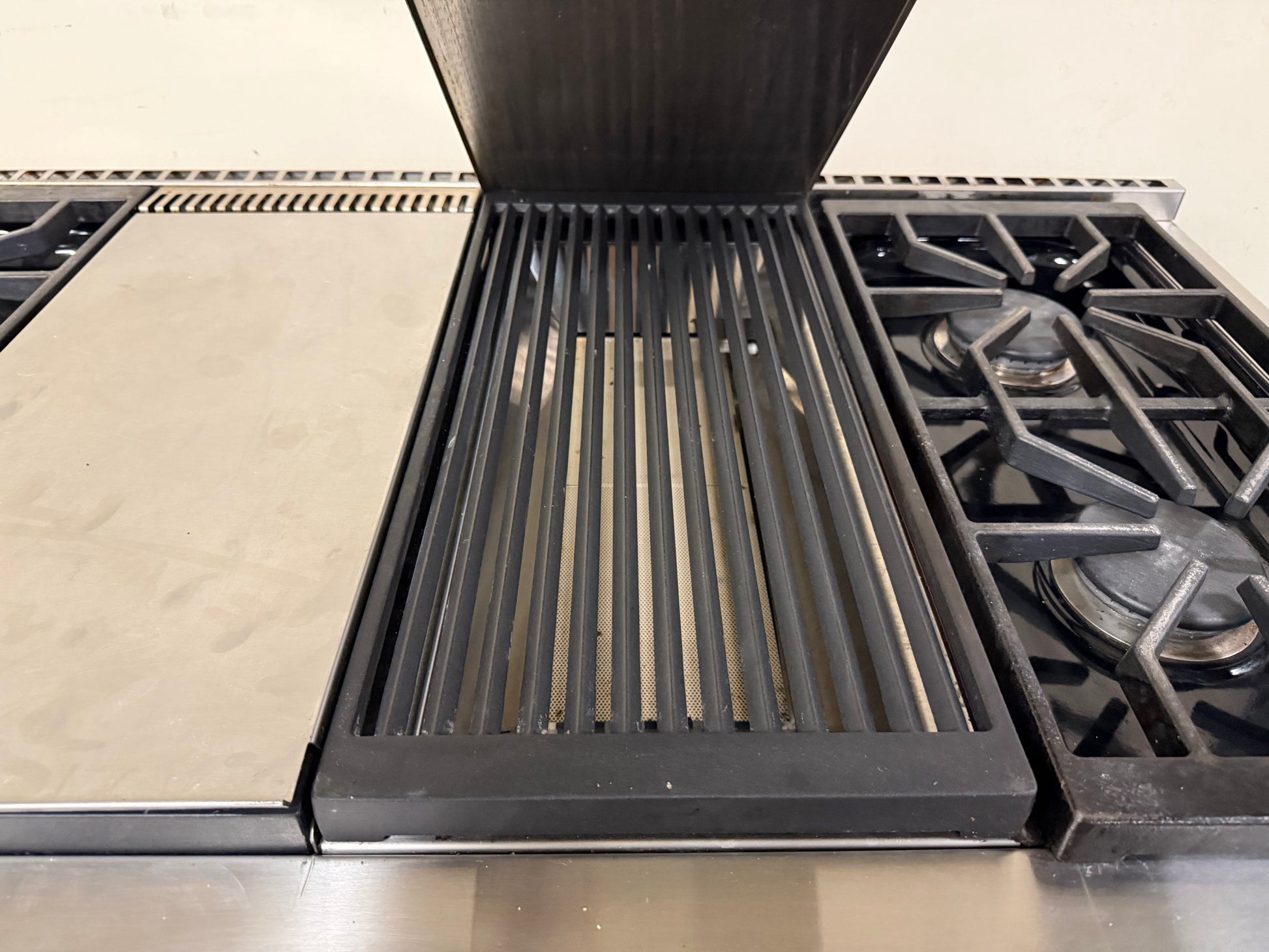 Heavy-duty porcelain-coated cast iron grates covering the six high-output gas burners.