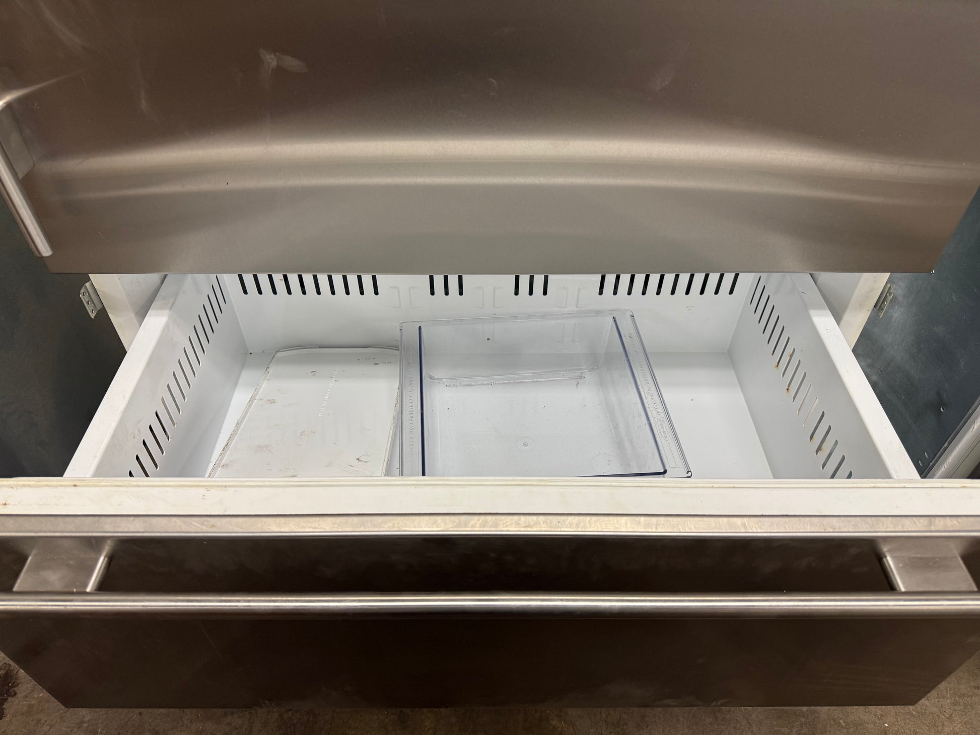 The pull-out bottom freezer drawer of the Sub-Zero 736TCI, showing the dual-tier storage baskets and automatic icemaker.
