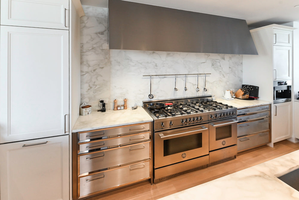 Modern kitchen with stainless steel appliances and marble backsplash