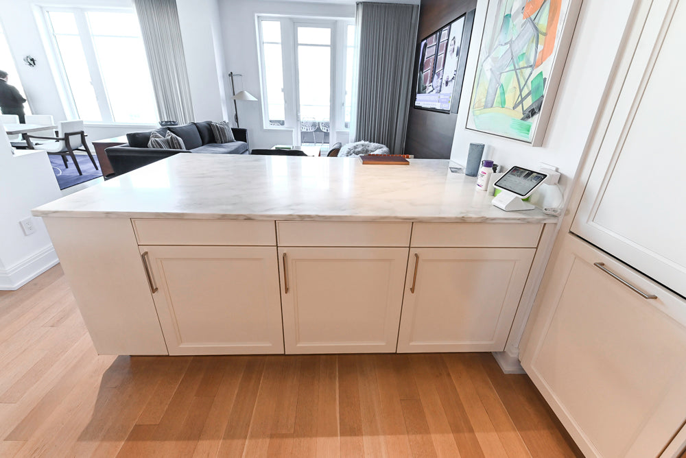 Modern kitchen island with marble countertop in a well-lit room.