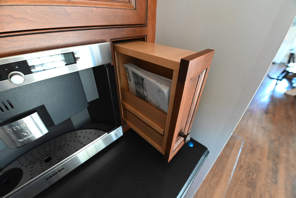 Modern kitchen setup with a coffee machine and wooden cabinet.