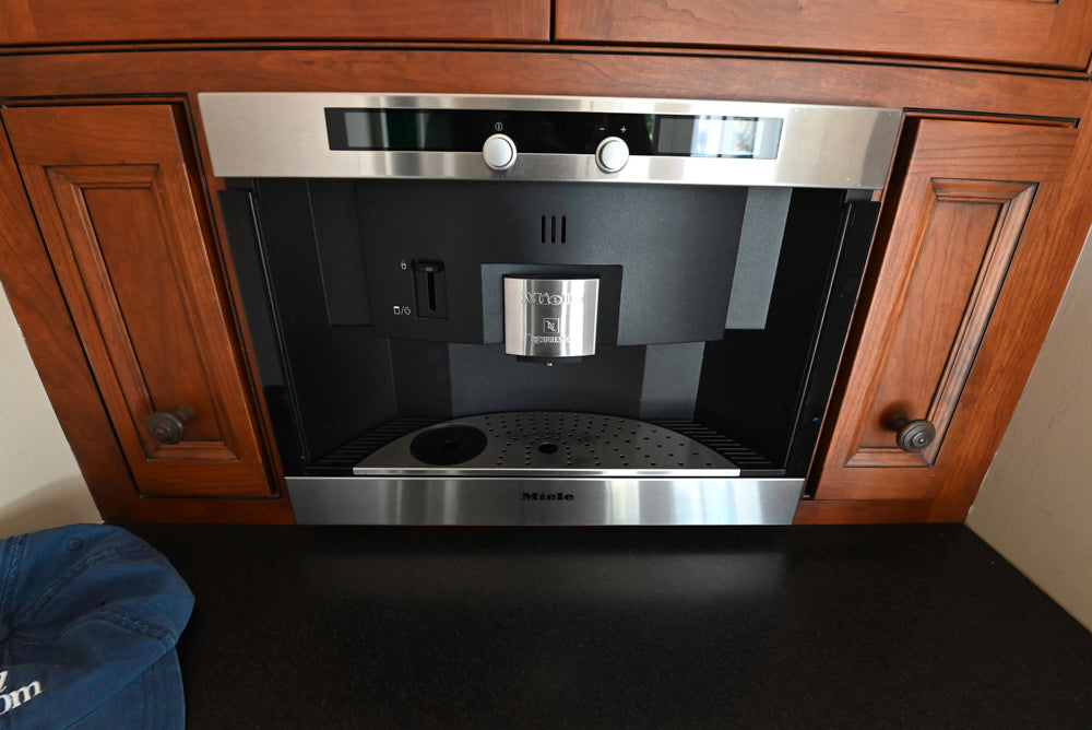 High-end wood cabinetry beverage station featuring built-in Miele espresso system
