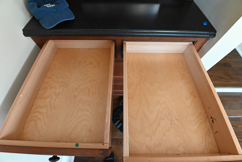Open wooden drawers with a black surface above them