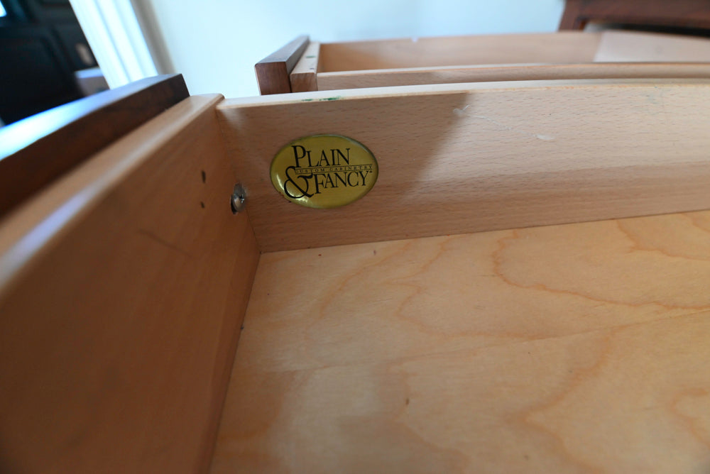 Wooden drawer with 'Plain & Fancy' label on a blurred background