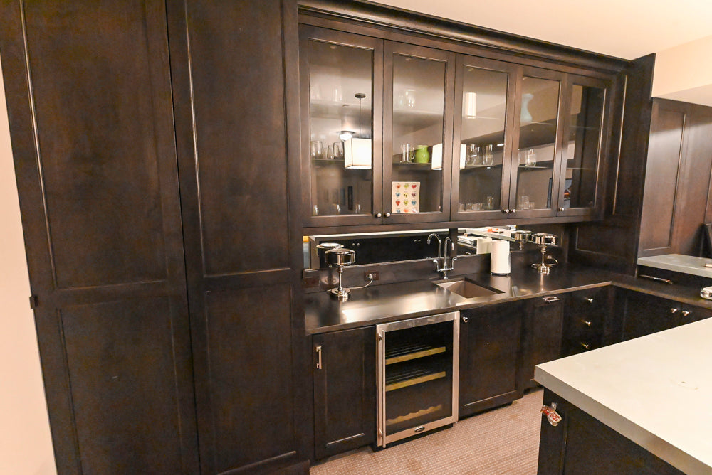 Luxury dark brown stained wood home beverage bar showing under mount sink and high arch faucet