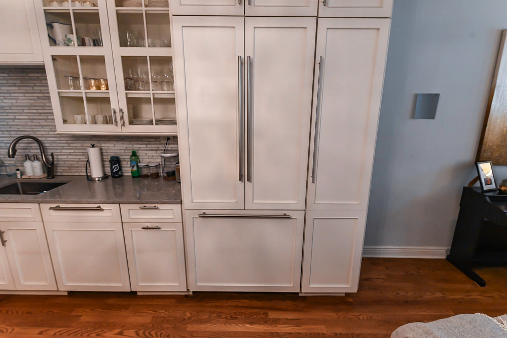 Modern kitchen with white cabinets, refrigerator, and countertop.