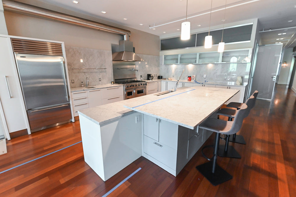 Minimalist white Italian kitchen island with professional stainless steel appliances