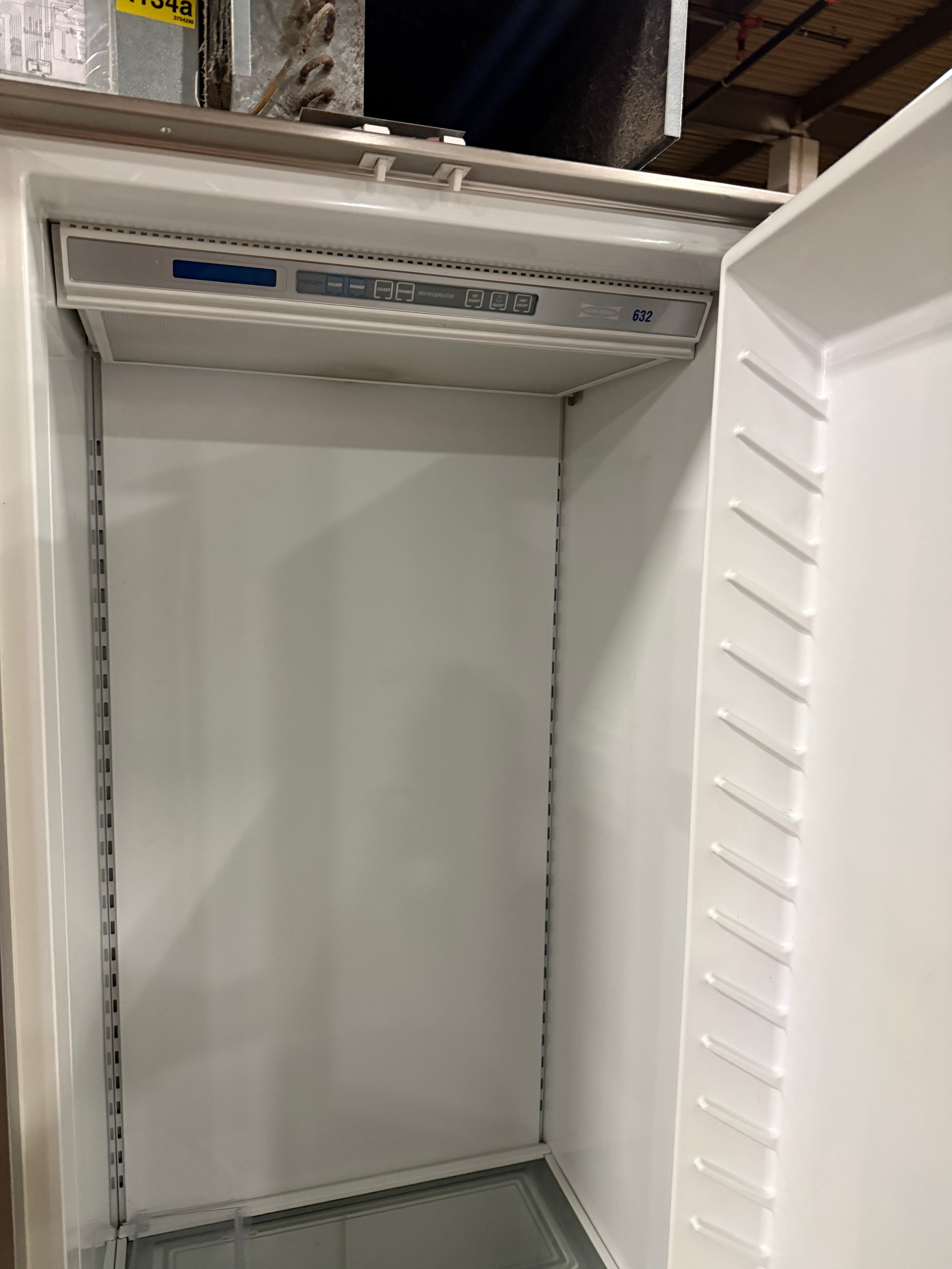 Open doors of a 48 inch stainless Sub-Zero 632/S refrigerator showing fully lit shelves and drawers