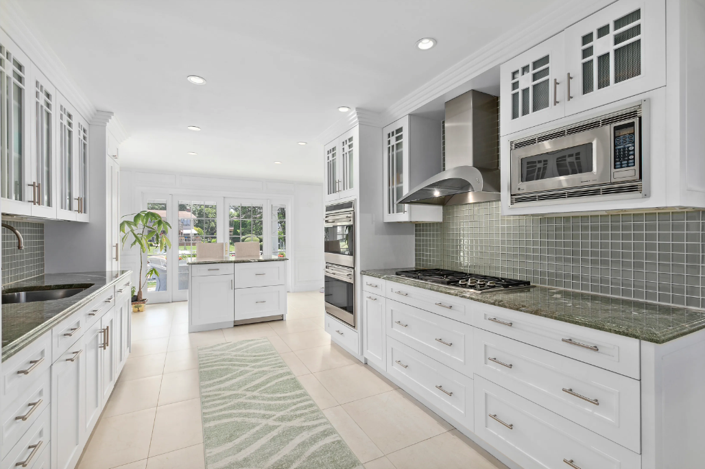 The Roxbury transitional white kitchen with central island and Sub-Zero refrigerator