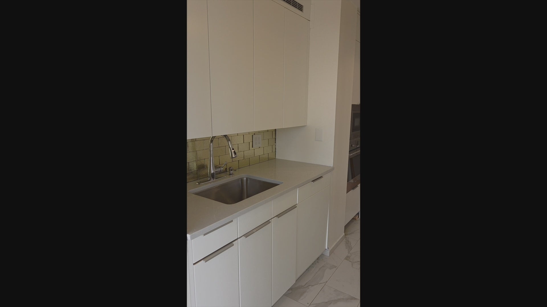 Load video: Minimalist Leicht cabinetry with white quartz countertops and integrated sink